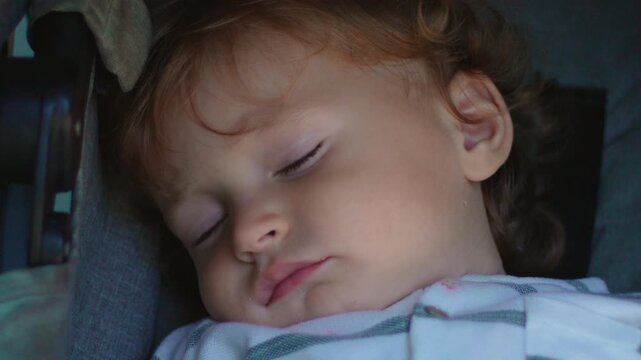 Sleeping toddler resting peacefully inside stroller during family outing capturing innocence, comfort and authentic early childhood rest moment