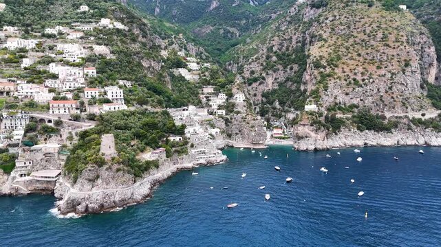 Aerial 4K drone video footage with panorama of Praiano town and coastline next to Marina di Praia, scenic Amalfi Coast landscape with Mediterranean seaside views in Italy