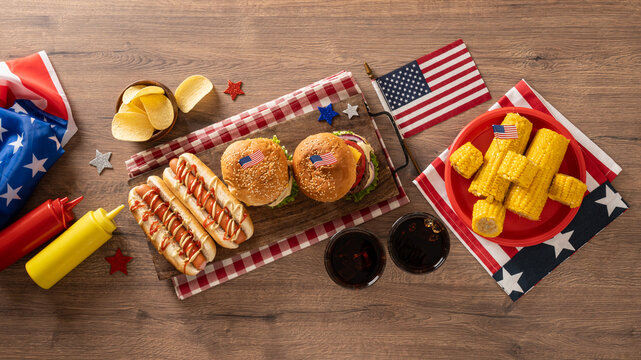 Fourth of July barbecue food flat lay with burgers hot dogs and corn