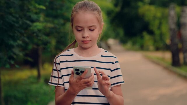 kid smiling while talking on phone outside, kid enjoying phone conversation in park, small child speaking on cell in nature, girl answering call in peaceful park, outdoor mobile chat with little girl
