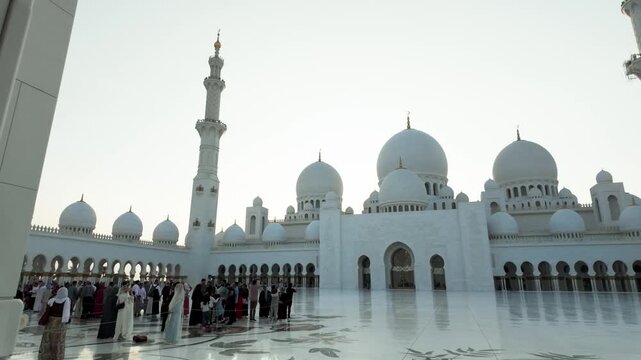 Elegant corner perspective of the iconic Sheikh Zayed Mosque showing detailed craftsmanship and polished marble reflections under a clear sky.