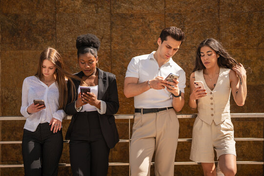 Young adults concentrating on smart phones displaying digital addiction