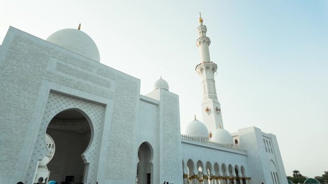 Elegant corner perspective of the iconic Sheikh Zayed Mosque showing detailed craftsmanship and polished marble reflections under a clear sky.