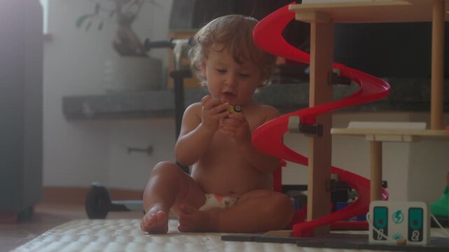 Toddler pushing toy car through a loop track on a coffee table in a modern living room highlighting hand-eye coordination and physical cause and effect
