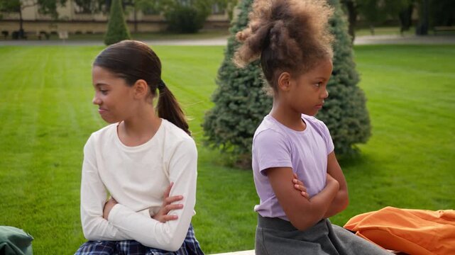 Offended little girls African American friends children quarrel problem outdoors sad worried kids multiethnic sisters schoolgirls pupils school students ignoring conflict apologizing ignore separated