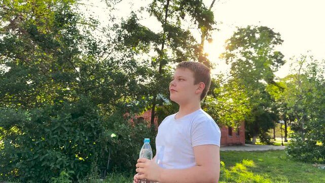 BABY BOY DRINKING WATER AT SUNSET PARK, DRINKING HEALTH REGIMEN, Child feeling refreshed, Hydration in motion, Water in sunny weather, Afternoon park session, Keeping cool, Summer safety tips, Teen