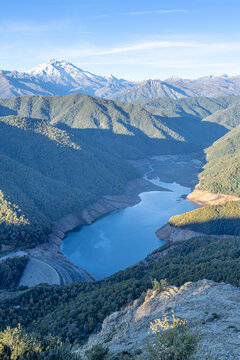 Parral, Maule Region - May 9, 2026: Mirador de los Riscos de Bullileo, from where you can see the Bullileo reservoir with little water reserve, and the Nevado de Longavi volcano, at sunset.