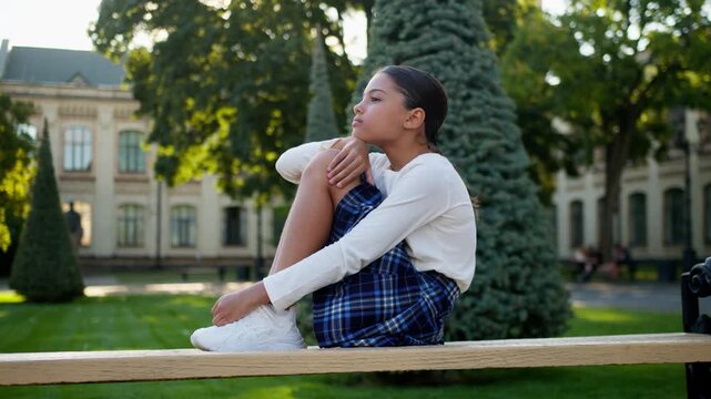 Sad lonely American Latina little girl school outdoor pensive learner thinking campus pupil student schoolgirl frustrated upset child kid teenager abuse daughter elementary education studying problem