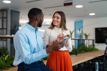 Diverse colleagues communicating on smartphones in modern office © Dexon Dee