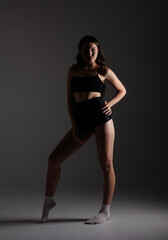 Fototapeta premium Model poses in studio with dramatic lighting and shadows showcasing strength and confidence