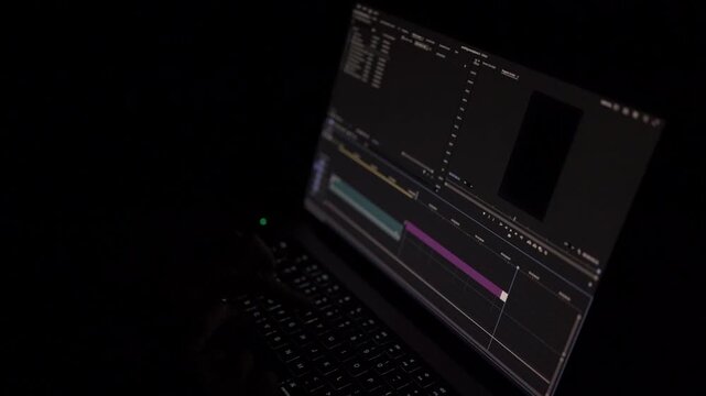 Close-up of video editing timeline and clips on laptop screen in dark environment. Concept of post-production, digital content creation and creative workflow.