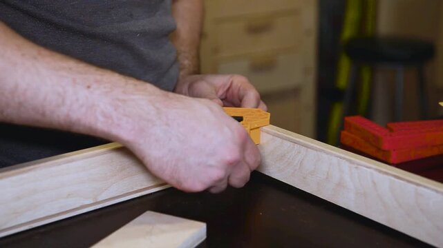 Set of clamps tools instruments for compressing and gluing wooden beams on work table in carpentry workshop, small business woodshop creating handmade items and furniture for home and living.