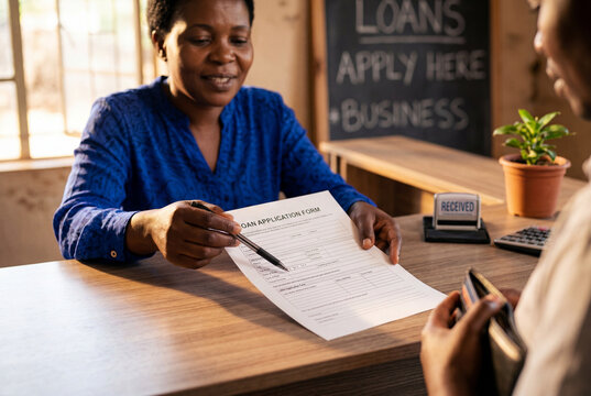 Female Loan Officer Assisting Customer with Loan Application at Community Finance Office