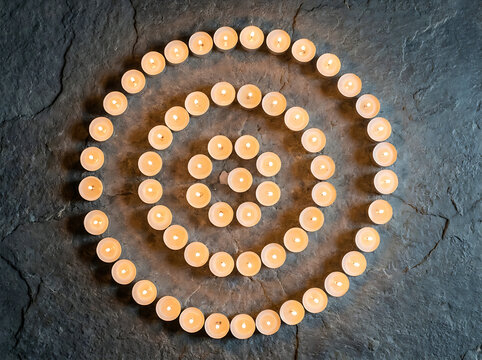 Lit candles arranged in a spiral pattern for a best friends celebration day warm glow