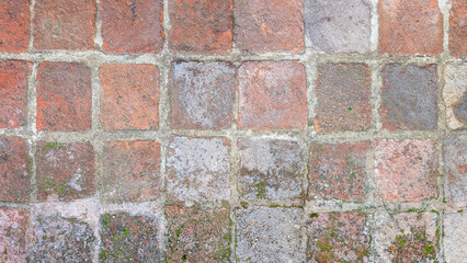 Old weathered brick pavement creating a structured pattern, displaying earthy tones and historic charm with natural aging and texture for urban design backgrounds © Newleks