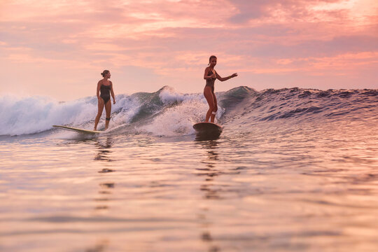 Two Surfers Sharing Sunset Swell, Matching Pace And Friendly Exchange, Mutual Support, Warm Orange Sky,
