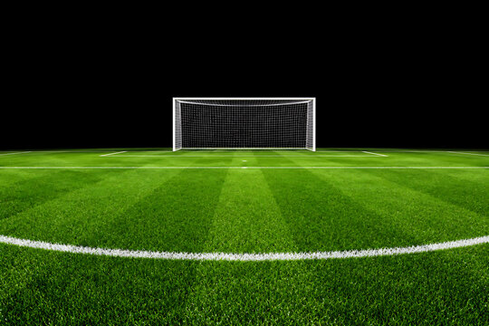 A soccer goal on a green field with white lines and a black background