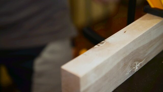 Wood lamella router in action cutting into a wooden surface. The spinning bit carves a precise groove as the attachment cutting into the material.