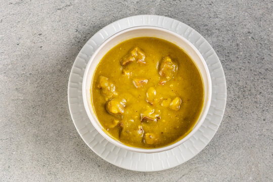 Homemade Split Pea Soup Served in White Bowl on Gray Table
