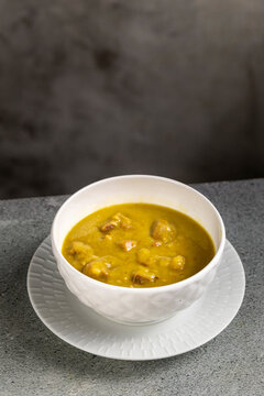 Homemade Split Pea Soup Served in White Bowl on Gray Table