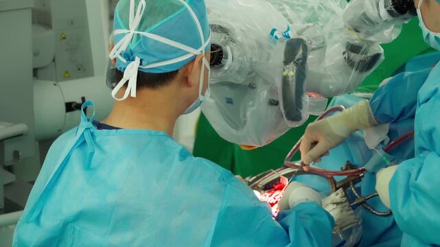 A medical professional performs a delicate brain neurosurgery procedure using an operating microscope in a surgical room surrounded by advanced monitoring