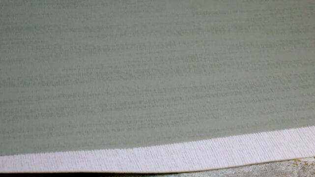 A designer slowly sorts through textile fragments. A close-up view of various wallpaper samples