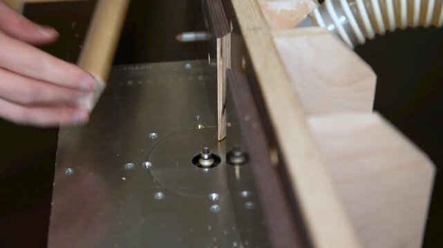 A carpenter uses a router tool for rounding the corner of the wood. shot highlights woodworking craftsmanship