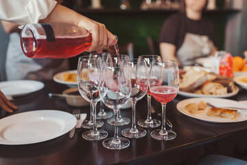 Obraz premium Friends gather around a table to enjoy food and drinks at a restaurant during a social event in the afternoon