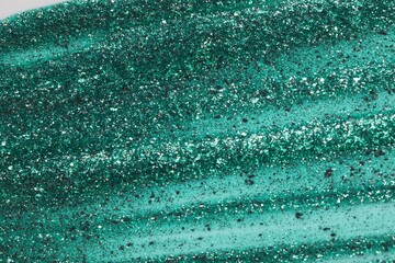 Obraz premium Green glitter nail polish as background, top view