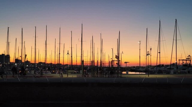 Senigallia pier and sail boats shilouettes at sunset, with beautiful orange sky. - Marche region, Italy