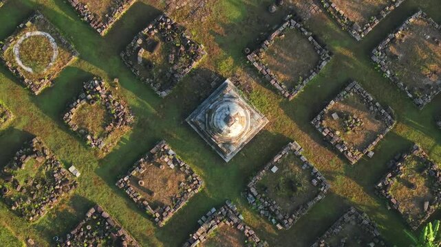 Aerial view of Plaosan Kidul Temple featuring the central stupa and surrounding stone ruins on green grass in Kecamatan Prambanan, Jawa Tengah, Indonesia.
