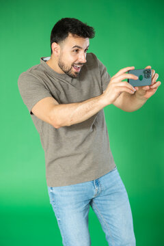 Man shoots video or photo content, reel maker, to capture excerpt from life. Young man scans QR code or takes photo, he saves important information on his phone.