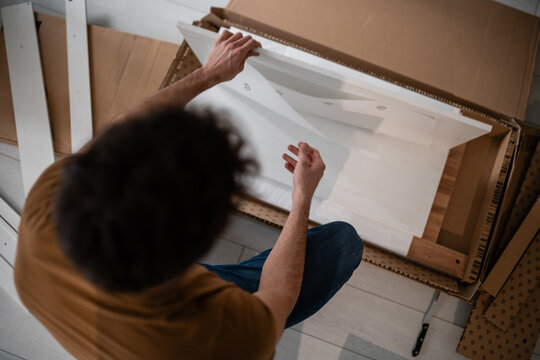 Man unpacking flat-pack furniture for diy assembly
