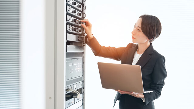 サーバーを点検する女性エンジニア