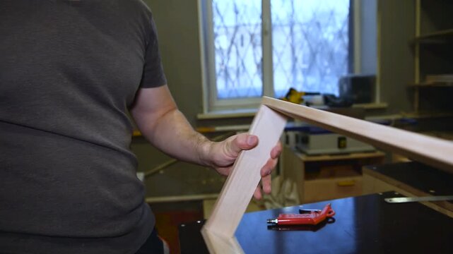 Pneumatic brad nailer securing to fasten the wooden planks, Nail gun drives fasteners smoothly, showing craftsmanship and professional home renovation work.