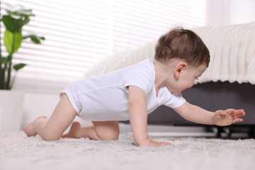 Fototapeta premium Cute little baby crawling on floor at home