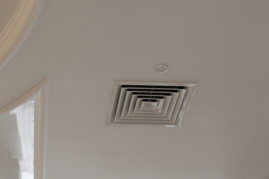 Square ceiling air vent diffuser mounted in a clean white interior, illustrating HVAC ventilation, airflow and climate control for residential or commercial spaces. Minimal design conveys comfort