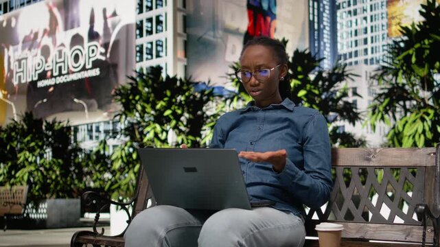Upset digital nomad girl struggling to work on laptop in the park, barely meeting deadlines. Worried remote worker doing freelancing outside, using notebook and feeling burnout, bad news.