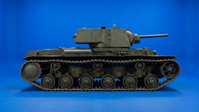 A side view of a realistic 3D Soviet heavy tank with a massive rectangular turret and dark metallic paint driving forward. This historical military vehicle asset is perfectly isolated on a blue screen