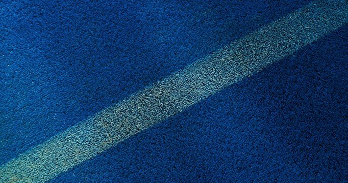 Extreme super slow motion close-up of a tennis or padel ball bouncing near the court line. Detailed blue surface texture captured at 1000fps with dynamic sports action in macro detail.