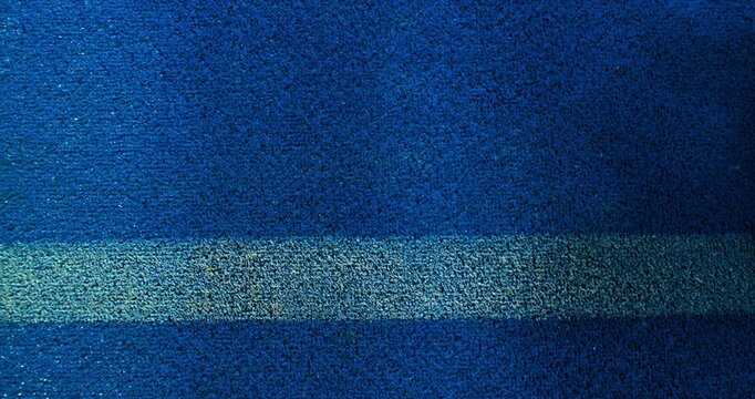 Extreme super slow motion close-up of a tennis or padel ball bouncing near the court line. Detailed blue surface texture captured at 1000fps with dynamic sports action in macro detail.