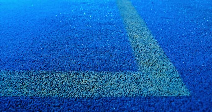 Extreme super slow motion close-up of a tennis or padel ball bouncing near the court line. Detailed blue surface texture captured at 1000fps with dynamic sports action in macro detail.