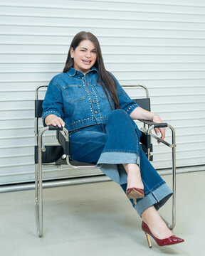 Confident Woman Sitting in Chair Wearing Denim Outfit