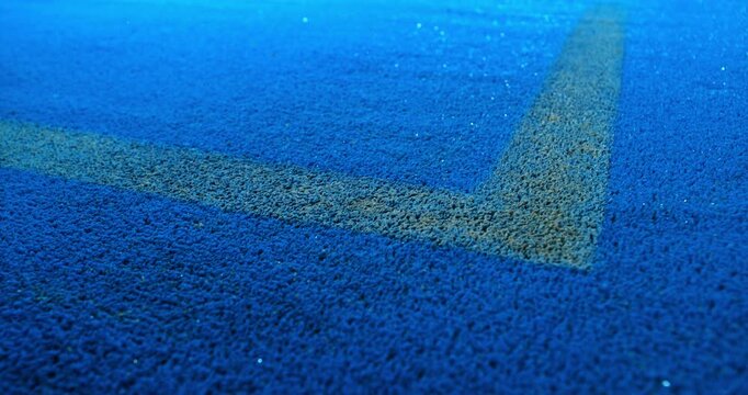 Extreme super slow motion close-up of a tennis or padel ball bouncing near the court line. Detailed blue surface texture captured at 1000fps with dynamic sports action in macro detail.
