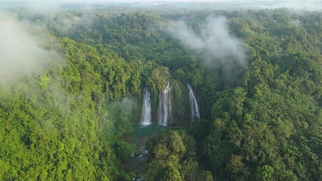Aerial view of Cikaso Waterfall cascading through dense tropical jungle with morning mist and lush greenery Sukabumi, West Java, Indonesia.