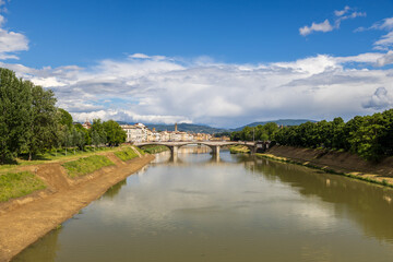 Fototapeta premium Arno River View with Historic Florence Buildings and Blue Sky