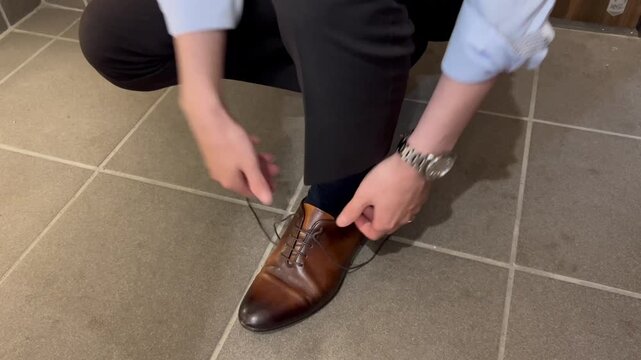 玄関で靴紐を結ぶビジネスマン
