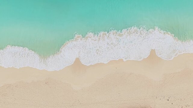 Aerial view of the turquoise waters and white sandy beach of Anse Reunion with gentle waves washing ashore in Anse Reunion, La Digue, Seychelles.