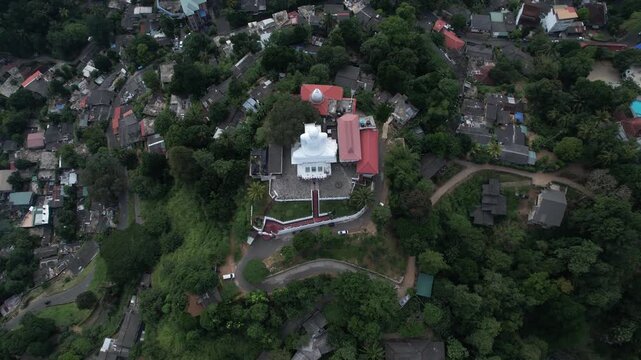 Aerial drone footage of the great Buddha Sri Maha Bodhi Viharaya in the city of Kandy, Sri Lanka, on a sunny day, 4k 30fps, 1 inch sensor