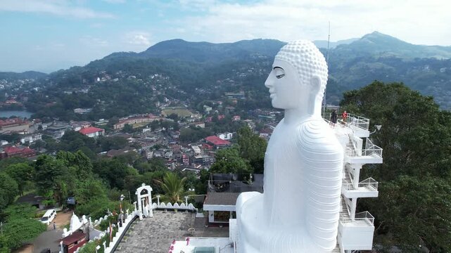 Aerial drone footage of the great Buddha Sri Maha Bodhi Viharaya in the city of Kandy, Sri Lanka, on a sunny day, 4k 30fps, 1 inch sensor